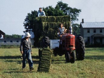 Bailing With A Farmall M - My Aunt Mary driving, Uncle Paul on the ground and  Uncle Mike on the wagon, bailing hay in the late  1940's