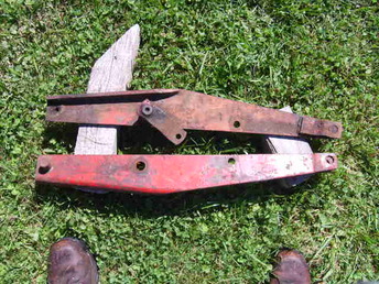 Coop Or Cockshutt?? - These look to be some kind of lift arm or lever.  One is Coop orange, the other is red with 1590 P stenciled on one side.  They are the same, not left and right hand.  The lever on the upper one goes through a sleeve and is free to torn.  I have the Coop cultivator for the E-3 but these don't seem to be part of it.