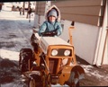 Lawn Tractor Photos From 1970S - Can anyone tell me the year and model of this tractor?  The photo is from the mid 1970s. I am the boy on the  tractor. This was my grandfather’s tractor. He lived in  northern NJ outside of NYC. I thought it was a cub  cadet but I cannot find a cub cadet with that split grill,  headlight configuration and vents on the side of the top  cover like this. I also do not see any cub cadet  logo/model number on the sides of the top cover.  Unfortunately this is the best photo I have. Any help  would be much appreciated. 