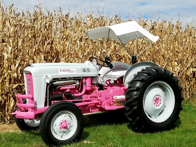 1963 Ford 4000 - October is National Breast Cancer Awareness  month. My farmer husband gave me this  tractor. I restored the 1963 Ford 4000 with  only one change. The royal blue factory  paint in hot pink.  Added are an umbrella,  mirror, SMV sign and side basket for tractor  rides. I am a nine year survivor!
