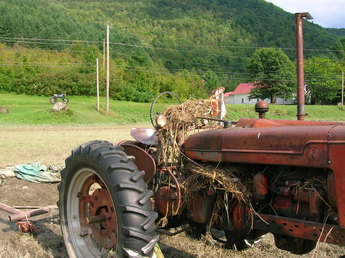 Farmall M After Irene - My whole spread of hay equipment was  parked on 'high ground' next to the  White river in Vermont, August 2011.  'High ground' wasn't high enough. By the  time I realized there was a problem, I  was cut off by five miles of flooded  roads, and overflowing bridges. The  river came up almost to the motorcycle  on the rock in the background. It was three days before I could even  get back there. The M is now running and  working.