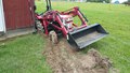 Yanmar 1500D - Juuuust trying to make a ditch and get  the water to run around the barn, not in  the barn... using the back blade. Blade  is all the way up now but still way in  the mud (sorry you can
