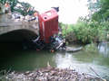 Massey VS Bridge - This happened just sw of me. Guy was driving it to his  other place when he failed to slow for the bridge.  Story is that he hit a bump and lost control and ended  up in the creek. Think header must have caught the  bridge and flipped him into the creek. Raised cane  with the old antique bridge.