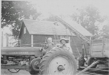 John Deere B - My Grandpa and I hauling grain (oats) with the John Deere 'B'.  Picture taken about 1950.  Grandpa traded this 'B' for a 51 'B', which my uncle still has. Anyone have an idea of the year?  We think it's early 40s, but no one can remember for sure.